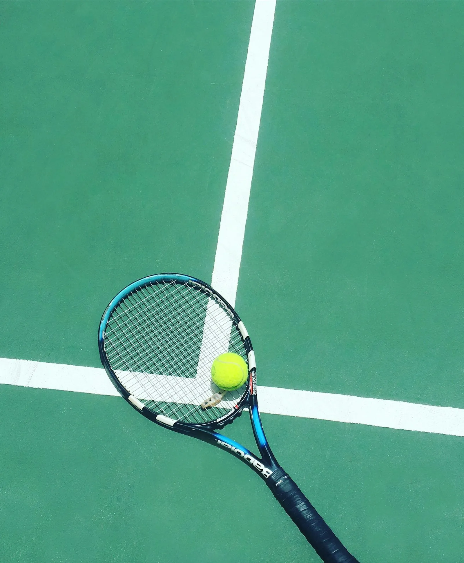 Raqueta y pelota sobre la cancha.